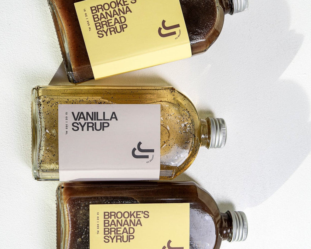 Three bottles of JJ's Syrup on a white background